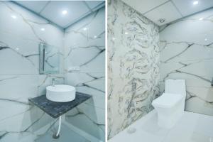 a bathroom with a marble wall and a toilet and a sink at Collection O Amer Jaipur Formerly Khandaka Villa in Jaipur