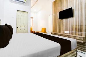 a bedroom with a bed and a flat screen tv at Super Collection O Ulhasnagar Birla Temple Formerly Hotel Yash Residency in Ulhasnagar +22 photos