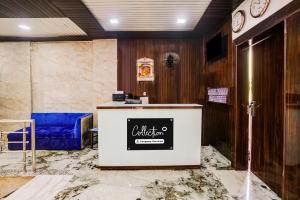 a reception desk in a room with a blue couch at Super Collection O Ulhasnagar Birla Temple Formerly Hotel Yash Residency in Ulhasnagar