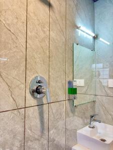 a bathroom with a shower with a sink and a mirror at Hotel Riva Inn in Miraj