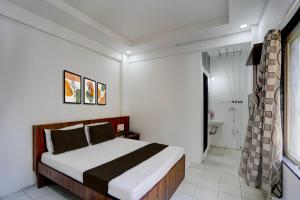 Un dormitorio con una cama grande y un baño. en Collection O Warje Pune Formerly Choice Guest house, en Yerandwane 21 fotos más