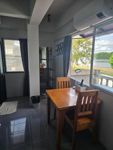 a dining room with a wooden table and a window at Funky Crab The River in Krabi