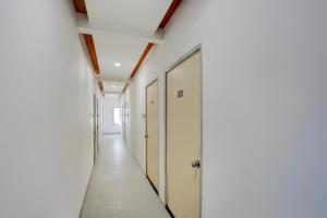 Un pasillo de un edificio de oficinas con paredes blancas y un pasillo largo. en Collection O Warje Pune Formerly Choice Guest house, en Yerandwane
