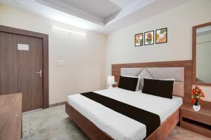 a bedroom with a large bed and a wooden door at Collection O Ranipur - Dhaney Crossway Formerly Saroj Inn in Bhāda +23 photos