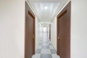 a hallway with doors and a checkered floor at Collection O Ranipur - Dhaney Crossway Formerly Saroj Inn in Bhāda