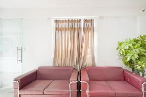 a living room with a pink couch in front of a window at Collection O Ranipur - Dhaney Crossway Formerly Saroj Inn in Bhāda