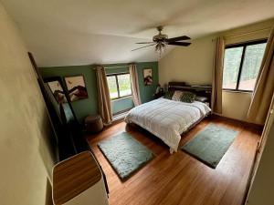 une chambre avec un lit et un ventilateur de plafond dans l'établissement Pocono Mountain Chalet, à Tobyhanna