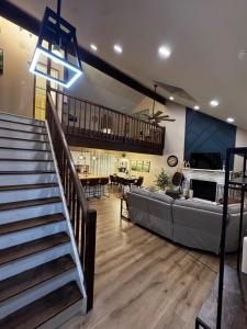 un grand salon avec un canapé et un escalier dans l'établissement Pocono Mountain Chalet, à Tobyhanna