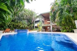 a large blue swimming pool in a yard with palm trees at Toro by Dreamcatcher in Santa Teresa Beach
