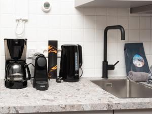 a kitchen counter with a sink and appliances on it at Luxury apartment in Renesse with infrared sauna in Renesse +32 photos