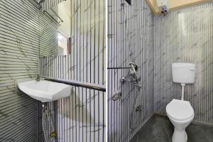 a bathroom with a toilet and a sink at Super Townhouse Pimple Nilakh Pune in Dāpuri