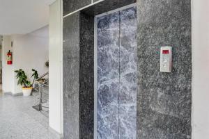 デヘラードゥーンにあるSuper Townhouse Oak ONGC Crossway Formerly Hotel Gold Stone Comfortの壁付きの部屋のガラスドア