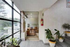 デヘラードゥーンにあるSuper Townhouse Oak ONGC Crossway Formerly Hotel Gold Stone Comfortの鉢植えの廊下 +23枚の写真