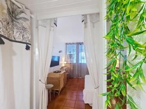 a hallway with white curtains and a desk in a room at Ti Mabouya Appartement Saint François in Saint-François