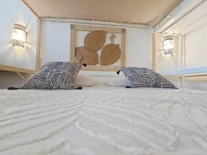a bedroom with a large white bed with two pillows at Ti Mabouya Appartement Saint François in Saint-François +26 photos