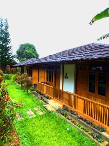 a house with a grass yard in front of it at Villa Kayu Danke in Ciguntur