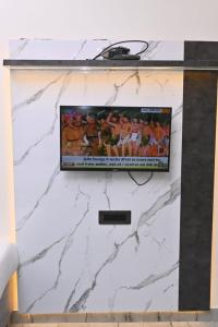 a flat screen tv on top of a white marble wall at Sunaina Palace in Varanasi +17 photos