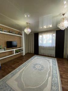 ein Wohnzimmer mit einem großen Teppich auf dem Boden in der Unterkunft Гостевой дом с 7 комнатами in Schymkent