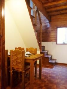 comedor con mesa, sillas y escaleras en Chalet Dominnycos, en San Cristóbal de Las Casas