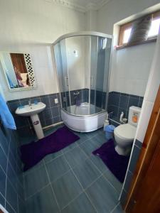 ein Badezimmer mit Dusche, Toilette und Waschbecken in der Unterkunft Гостевой дом с 7 комнатами in Schymkent + 25 Fotos