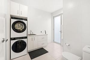 a white bathroom with a washer and dryer at Callala Chill Jervis Bay - Short Walk to Creek in Callala Bay +21 photos