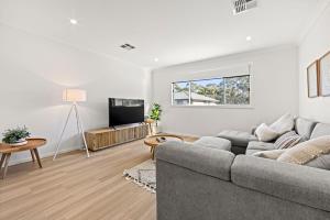 a living room with a couch and a tv at Callala Chill Jervis Bay - Short Walk to Creek in Callala Bay