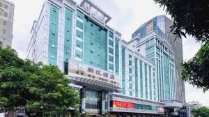 een hoog gebouw met glazen ramen in een stad bij Xana Lite Heyuan Shanghui Building Bus Station in Heyuan