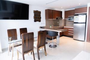 a kitchen with a table and chairs and a refrigerator at Perfecta Suite En Samborondon Plaza in Guayaquil