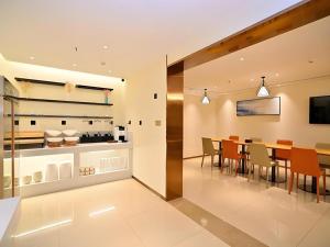 a kitchen and dining room with a table and chairs at City Comfort Inn Kunming High Speed Railway South Station Yongxin Harvard in Kunming