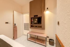 a living room with a tv on a wall at Legacy Inn, Mysore in Mysore