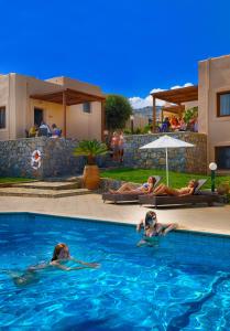 two people are swimming in a swimming pool at Ida Village I & II in Hersonissos