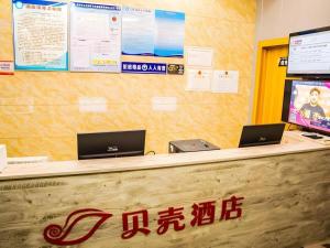 a counter with two laptops on top of it at Shell Hotel Jiangxi Fuzhou Linchuan Avenue in Shiliting