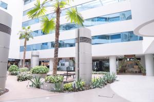 a building with palm trees in the courtyard at Perfecta Suite En Samborondon Plaza in Guayaquil