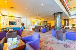 een lobby van een hotel met blauwe stoelen en tafels bij Jinjiang Hotel Qianan in Qian'an
