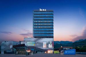 Un edificio alto con un cartel encima. en IU Hotel Chongqing Airport T3 Terminal, en Chongqing