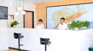 two people standing behind a counter in a bathroom at Green Tree Inn Express Xingtai Guangzong Development Zone Xingqing Road in Guangzong