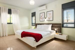 een slaapkamer met een groot wit bed en ramen bij Tranquil Galilee Countryside Retreat by Sea N' Rent in Tefahot