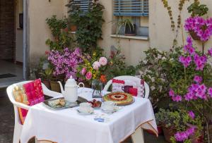 een tafel met een wit tafelkleed en bloemen bij La Ginestra casa vacanze in Milo