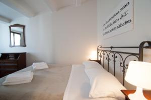 ヴェネツィアにあるSanta Maria Formosaの白いシーツと鏡が付いたベッドのある寝室