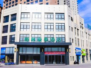 een groot wit gebouw met een bord erop bij GreenTree Inn Shanxi Linfen Huozhou High-Speed Railway Station in Huozhou