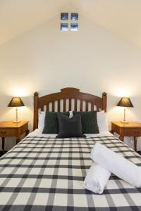 ein Schlafzimmer mit einem schwarz-weiß karierten Bett in der Unterkunft Petersons Wines Dairy Cottage in Pokolbin