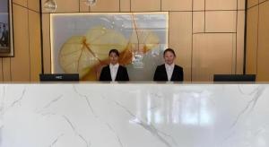 twee vrouwen in pak zitten aan een tafel met laptops bij GreenTree Inn Express Shandong Jinin Jiaxiang Railway Station in Jiaxiang