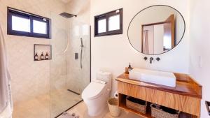 a bathroom with a toilet and a sink and a mirror at Villa Damiana Boutique Hotel and Villa in El Pescadero +15 photos