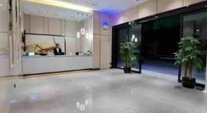 a lobby with a man standing in a building at GreenTree Inn Express Fuzhou Linchuan District Gandong Auto City in Shiliting