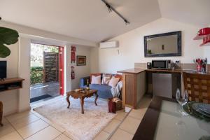 ein Wohnzimmer mit Sofa und Tisch in der Unterkunft Petersons Wines Dairy Cottage in Pokolbin