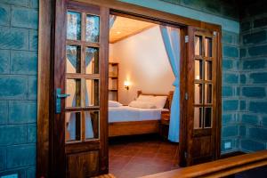 Habitación pequeña con cama y puerta de cristal en Babylon Lodge, en Marangu