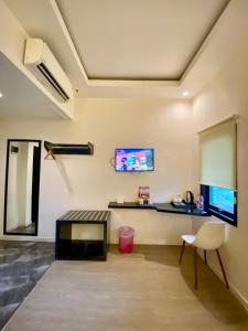 a living room with a tv on the wall at Rid's Hotel Palembang in Talang Kelapa