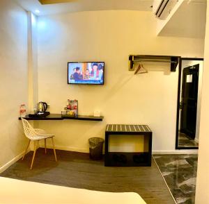 a living room with a tv on the wall at Rid's Hotel Palembang in Talang Kelapa +17 photos