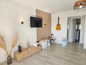 a living room with a flat screen tv on a wall at Panorama Sun Figueira - 1er ligne Mer in Figueira da Foz