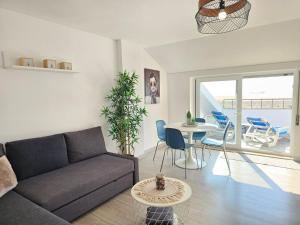 a living room with a couch and a table at Panorama Sun Figueira - 1er ligne Mer in Figueira da Foz